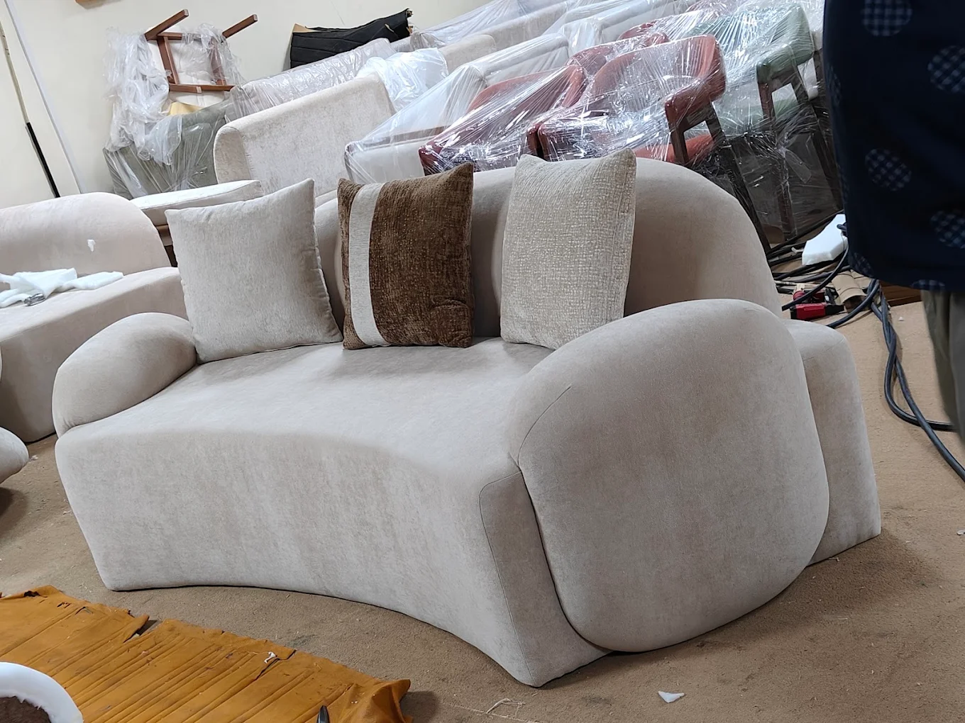Modern curved lounge chair reupholstered in beige fabric